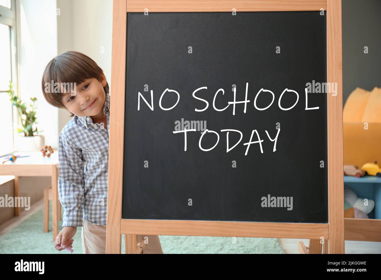 Cute little boy and chalkboard with written text NO SCHOOL TODAY in