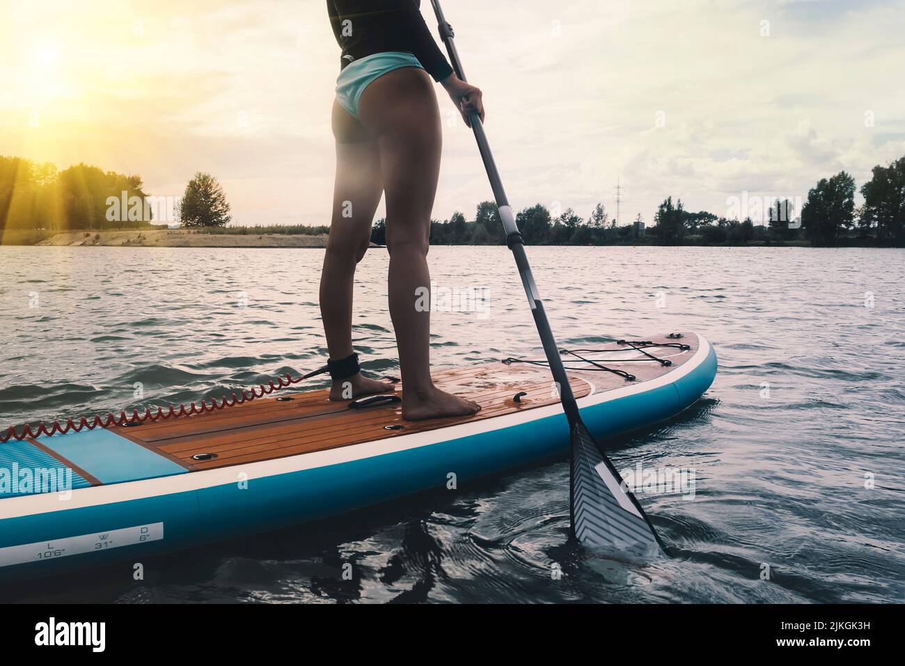 Young women Having Fun Stand Up Paddling in blue water sea. SUP. girl