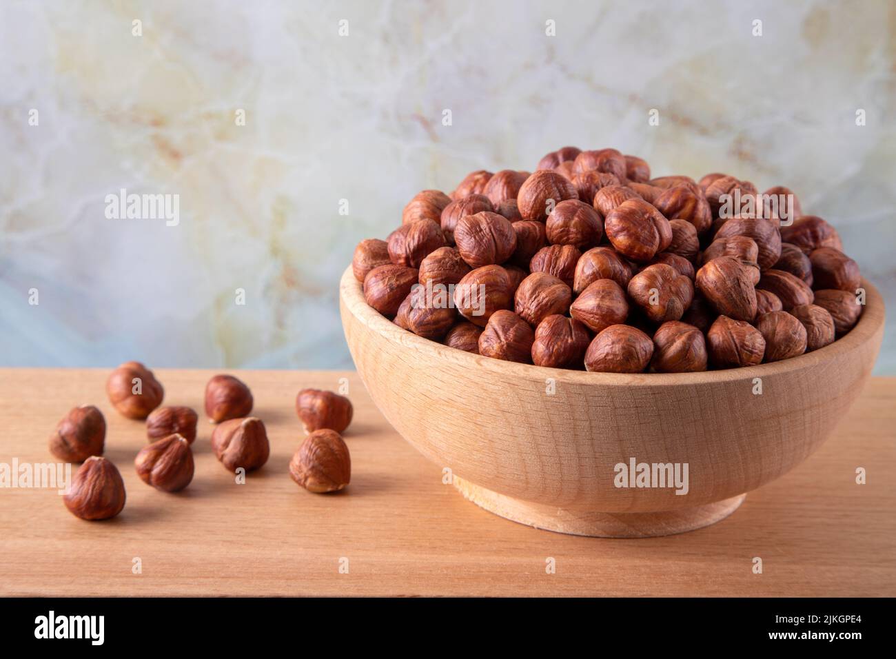 Bowl full of hazelnuts  on wooden background Stock Photo