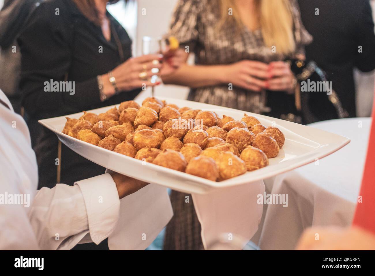 The waiter serving snacks to the guests Stock Photo - Alamy