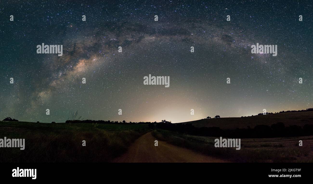 A night view of a road under milky way arch in the sky Stock Photo - Alamy