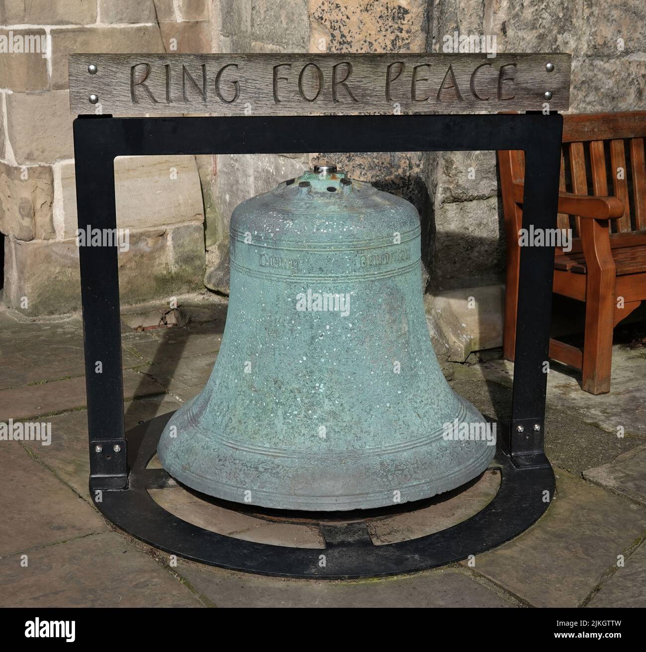 A medieval bell with the inscription Ring For Peace outside the Holy Trinity Church in York, UK Stock Photo