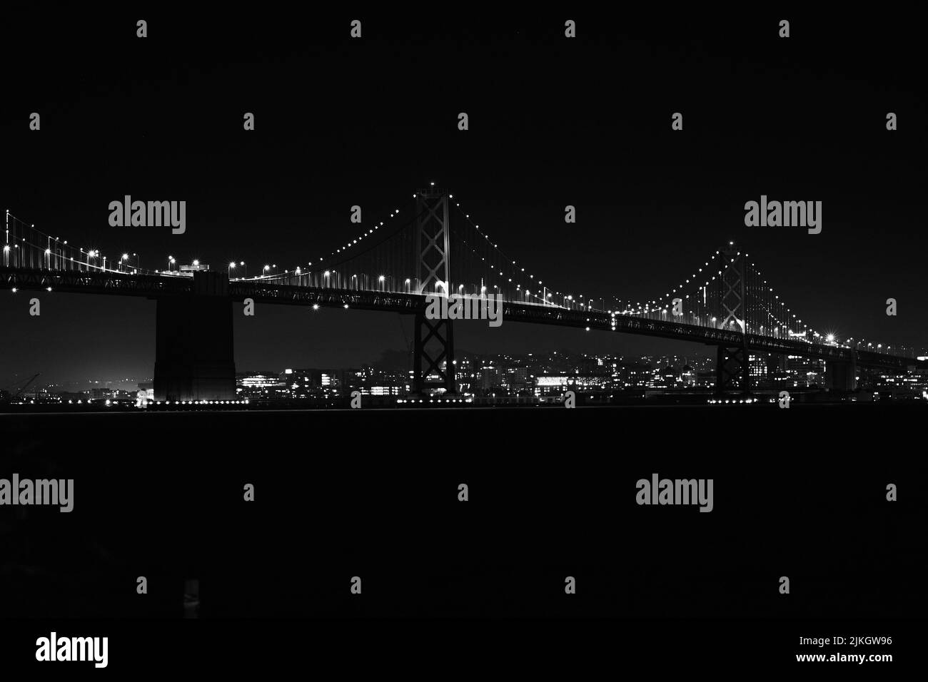 A grayscale of the shiny  Oakland Bay Bridge at night in San Francisco, USA Stock Photo