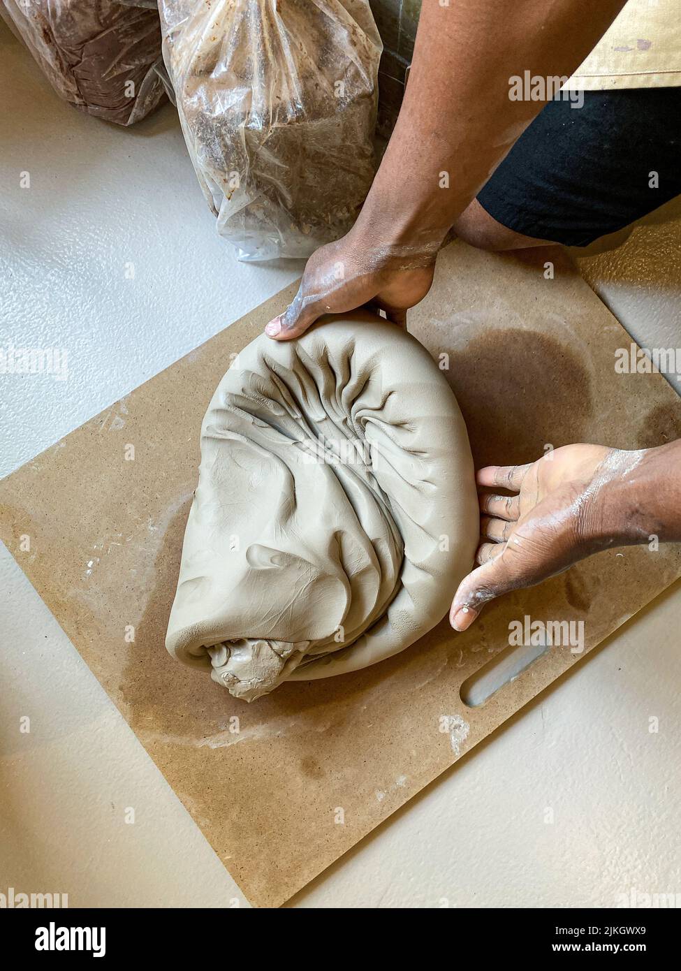 A man wedging clay using the Spiral Wedging technique Stock Photo Alamy