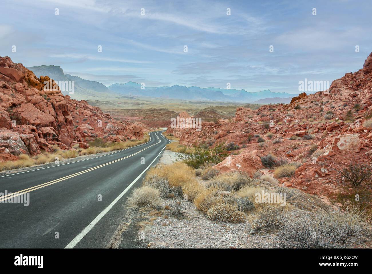 Empty two-way highway leading to the Valley of Fire surrounded by sandstone rocks Stock Photo