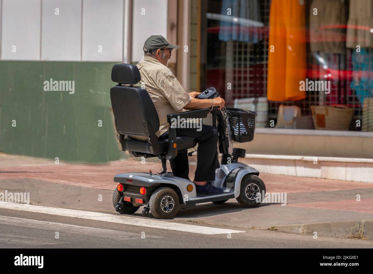 ronda,malaga,spain june 20, 2022 man with reduced mobility in electric car crossing the street Stock Photo