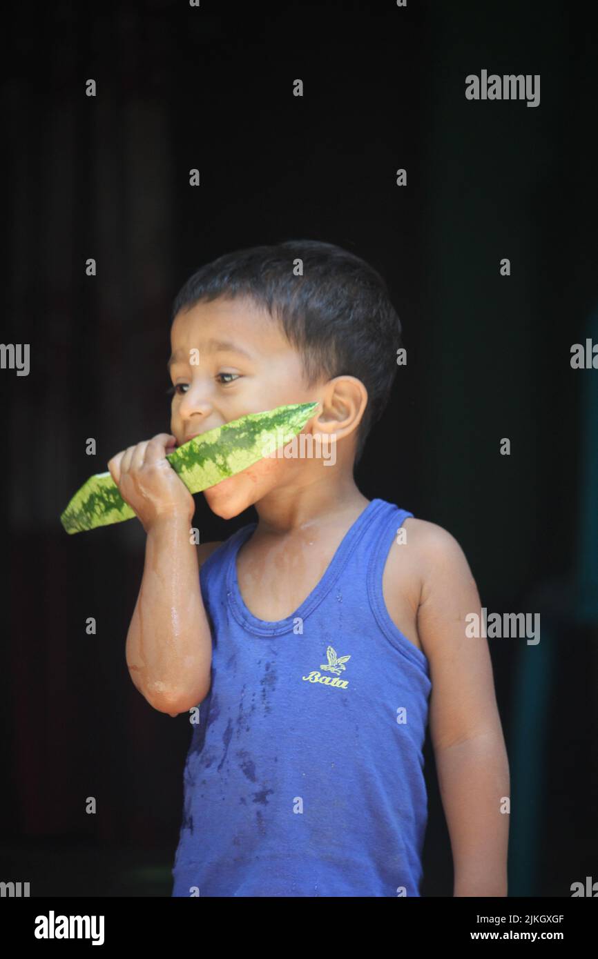 08 april 2022 Barguna, Barishal, Bangladesh. A child is eating watermelon. Stock Photo