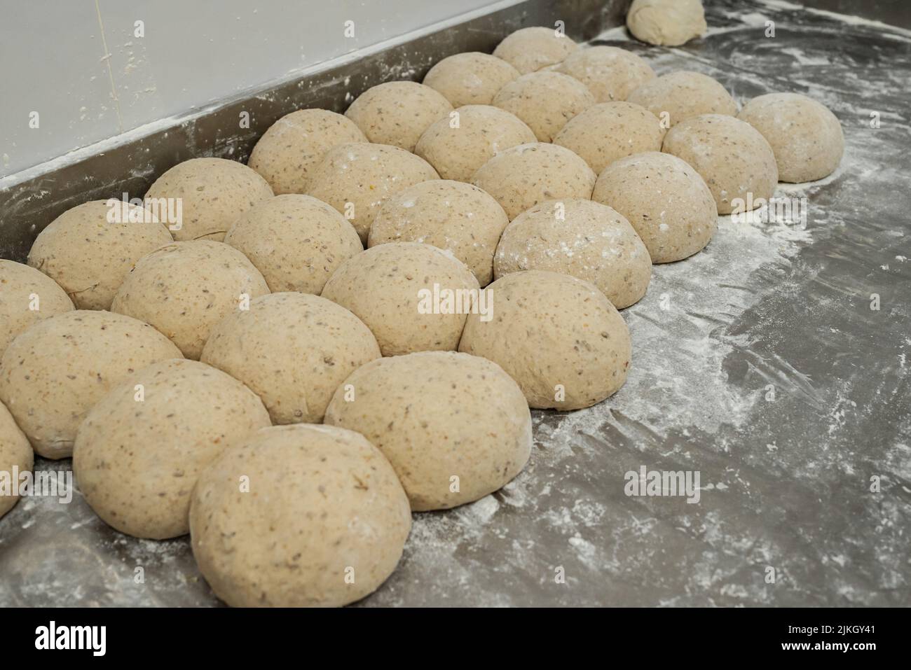 A closeup shot of round pieces of dough covered with flour for bread Stock Photo