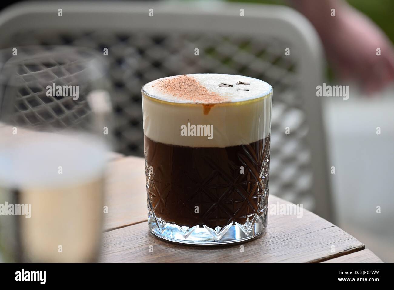 The Irish coffee in glass on wooden table at restaurant , close-up Stock Photo