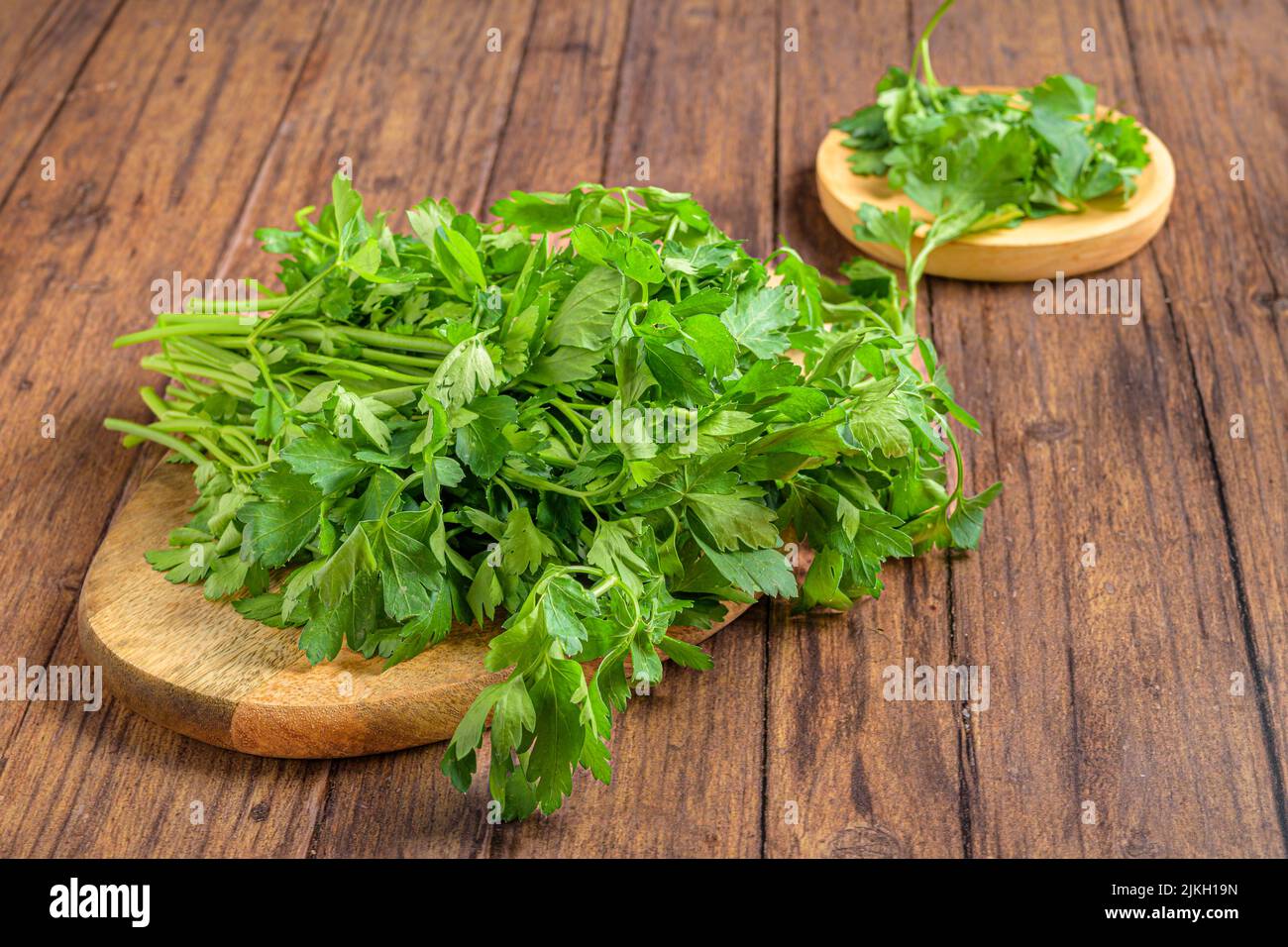 A closeup shot of fresh parsley (Petroselinum crispum) on the wooden trays Stock Photo