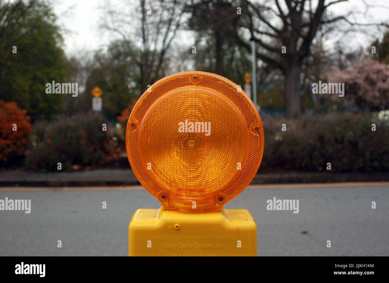 A closeup shot of a yellow signal lamp on the road Stock Photo