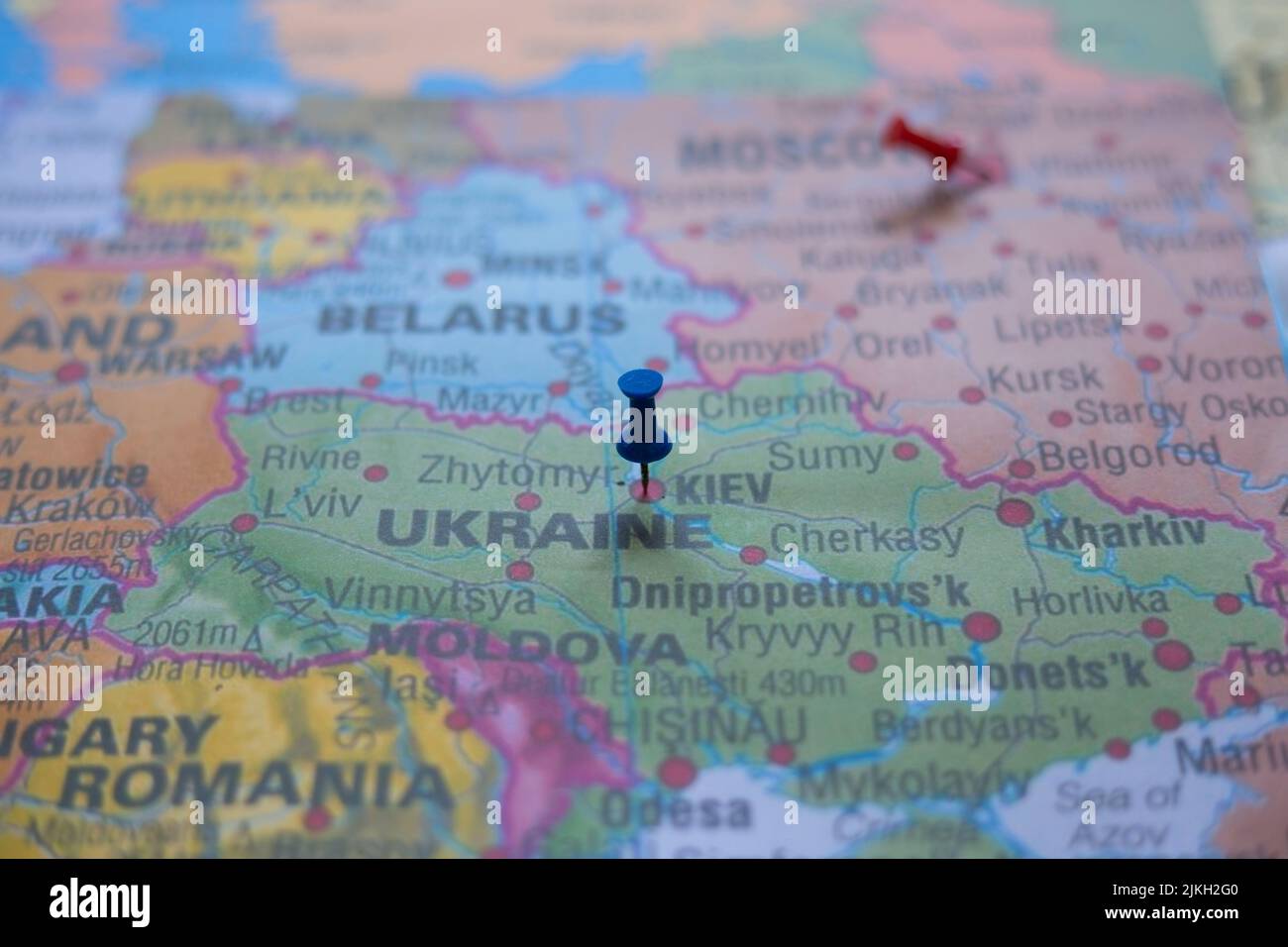 A close-up shot of the map of Europe with the capital city of Ukraine, Kiev, pinned on it with a blue pin Stock Photo