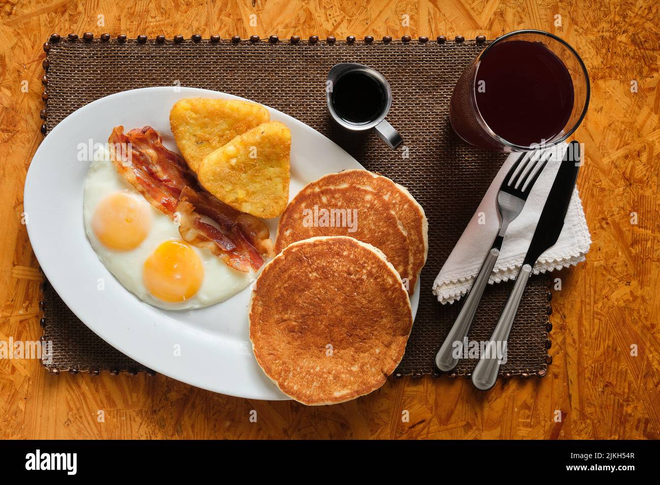 A top view of a traditional American breakfast with pancakes, bacon, eggs, and hash browns Stock Photo