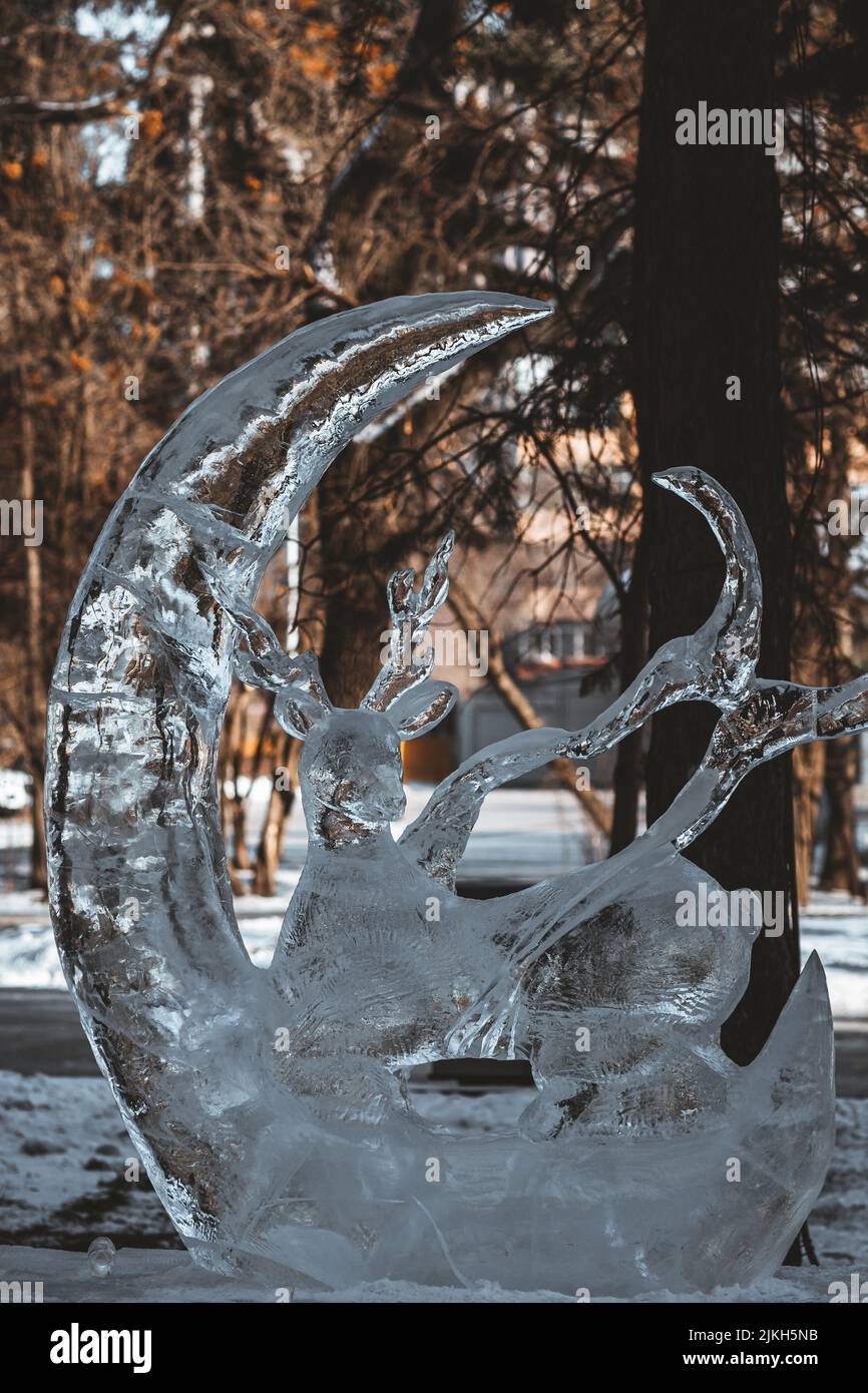 A vertical shot of ice sculpture of a deer dragon in the forest Stock ...