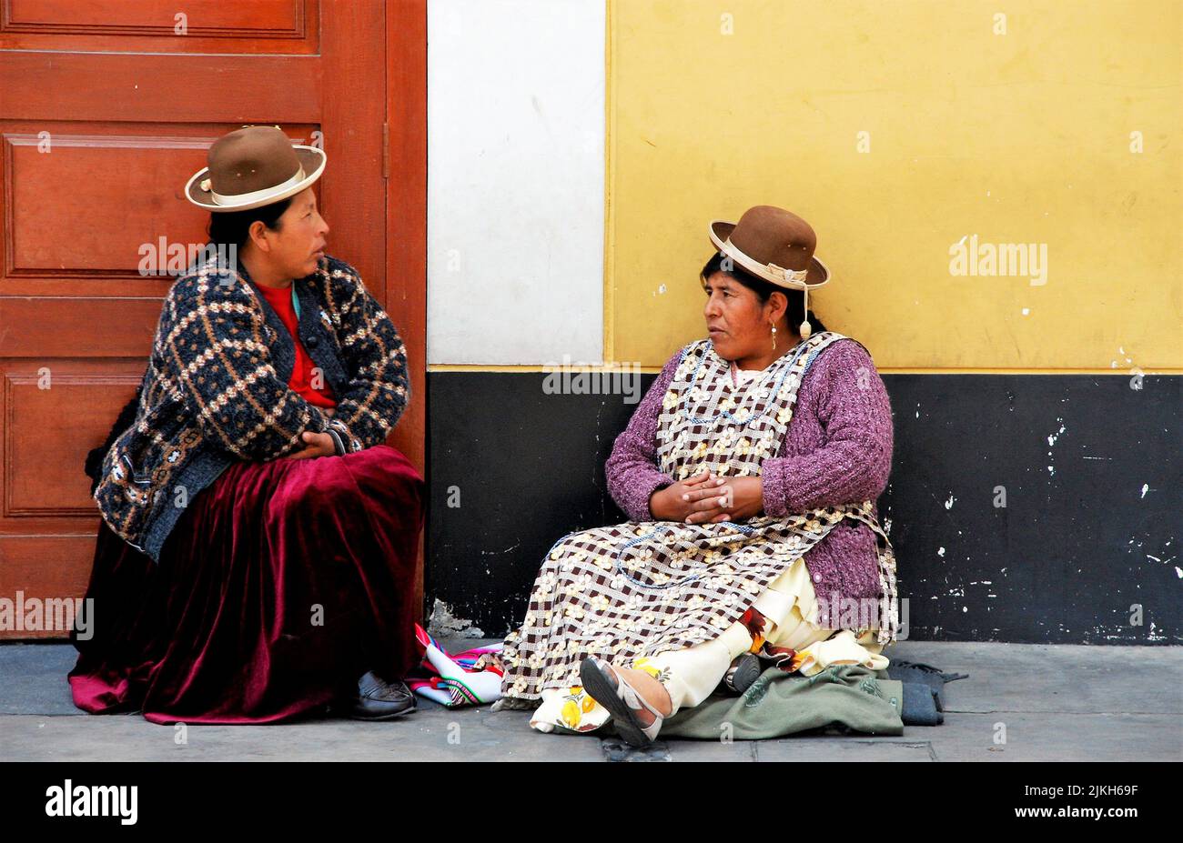 Two women dressing in traditional clothing near the main market of