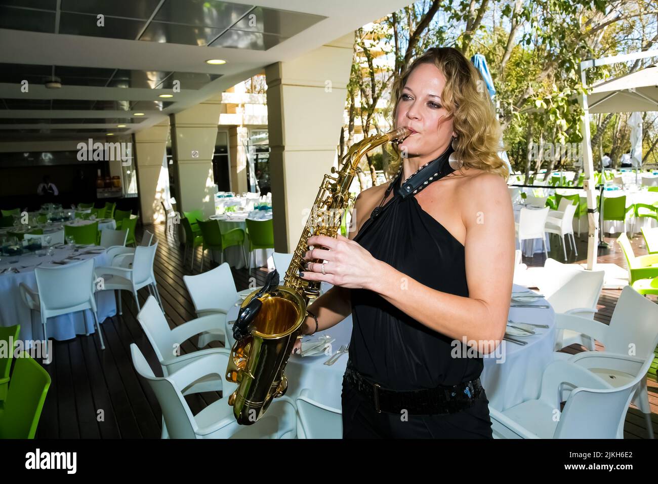A female musician playing saxophone at outdoor venue Stock Photo