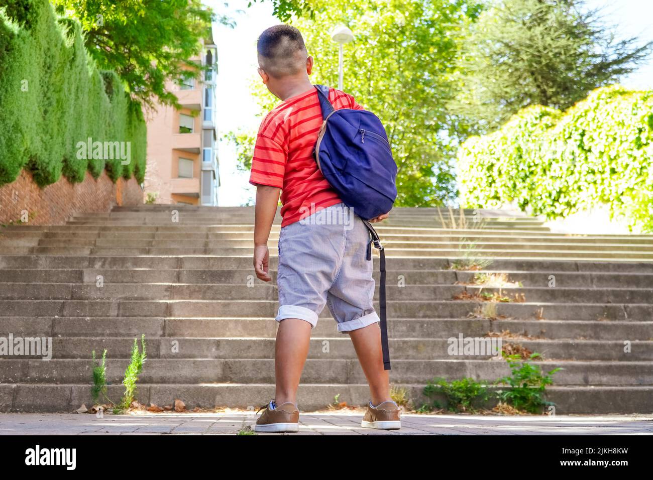 Filipino boy with backpack on the way to school. Back to school concept. Multiethnic children group Stock Photo