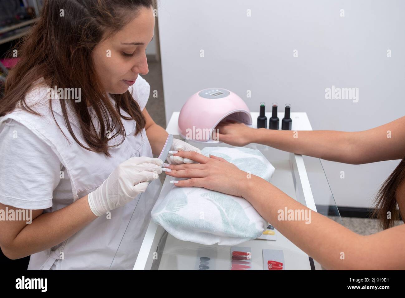A woman in beauty center performing a nail service and beautification