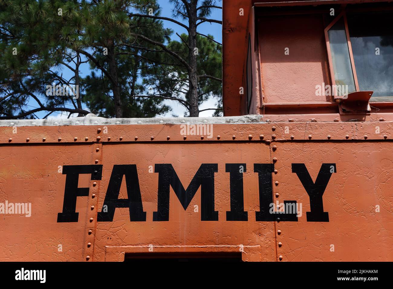 A closeup shot of the word 'FAMILY' painted in black on an orange metal surface Stock Photo