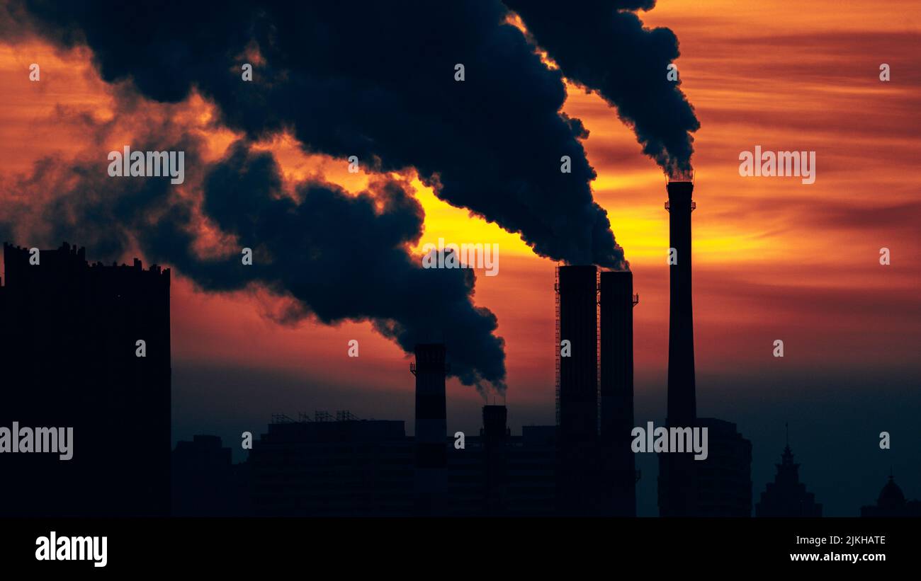 An Industrial Factory With Smoke At Sunset Concept Of Air Pollution An industrial factory with smoke at sunset concept of air pollution