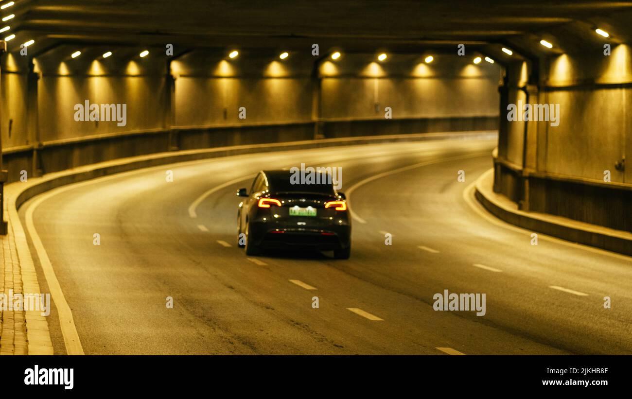 A modern car driving in a modern tunnel at night with lights Stock