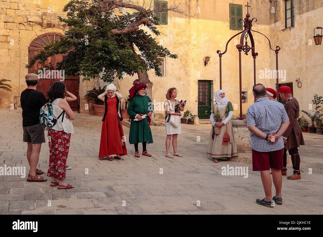 A lady dressed in a period costume as a herbalist explains to an audience herbs and their uses in a reenactment of 15th century life at Mdina, Malta, Stock Photo