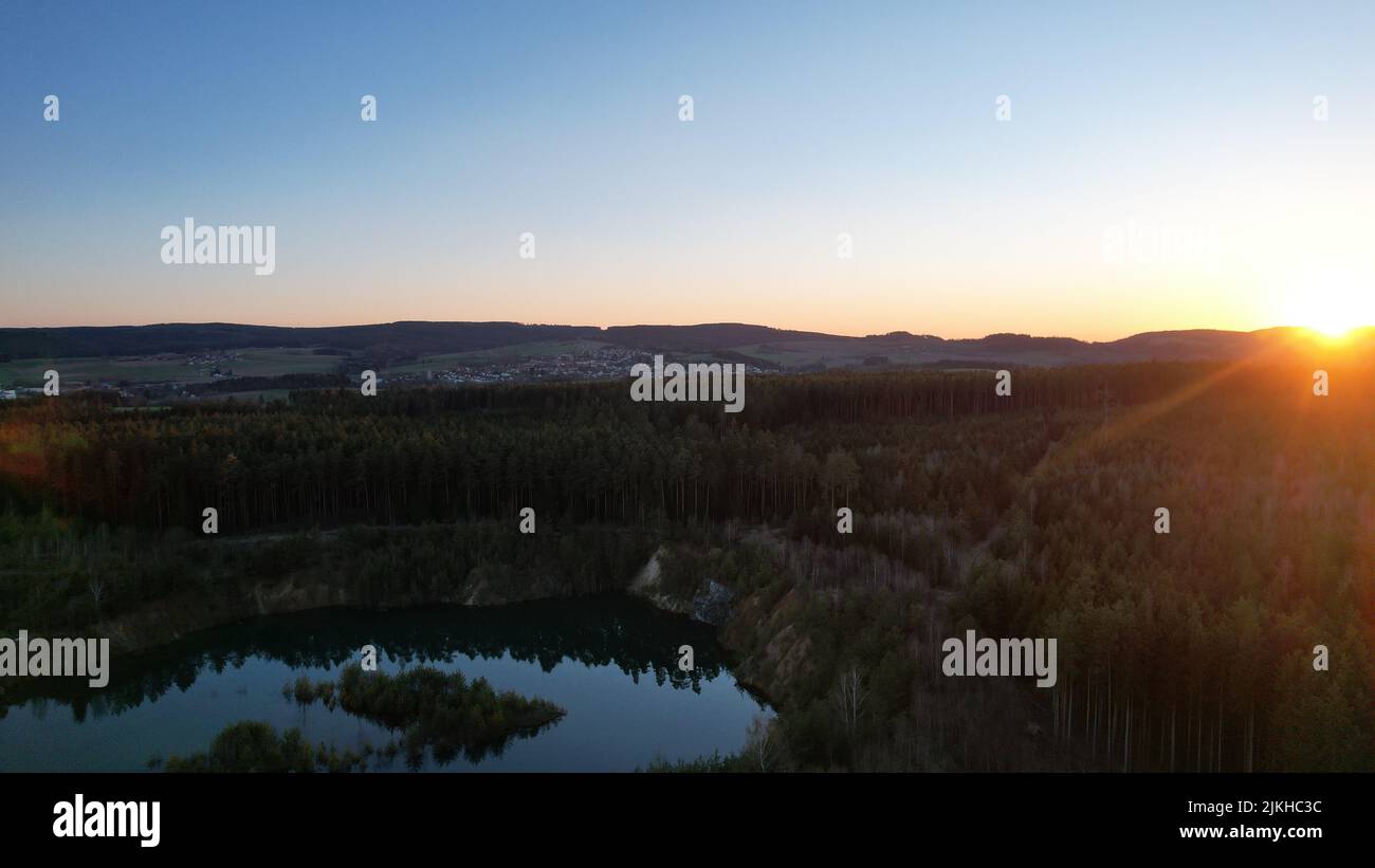 A mesmerizing scene of forest trees around a reflectng lake under ...