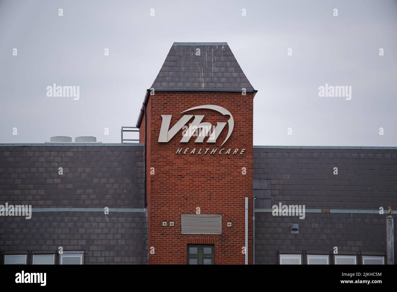 The VHI Healthcare logo mounted on the tower of a red brick building. The VHI is well known health insurance company in Ireland. Stock Photo