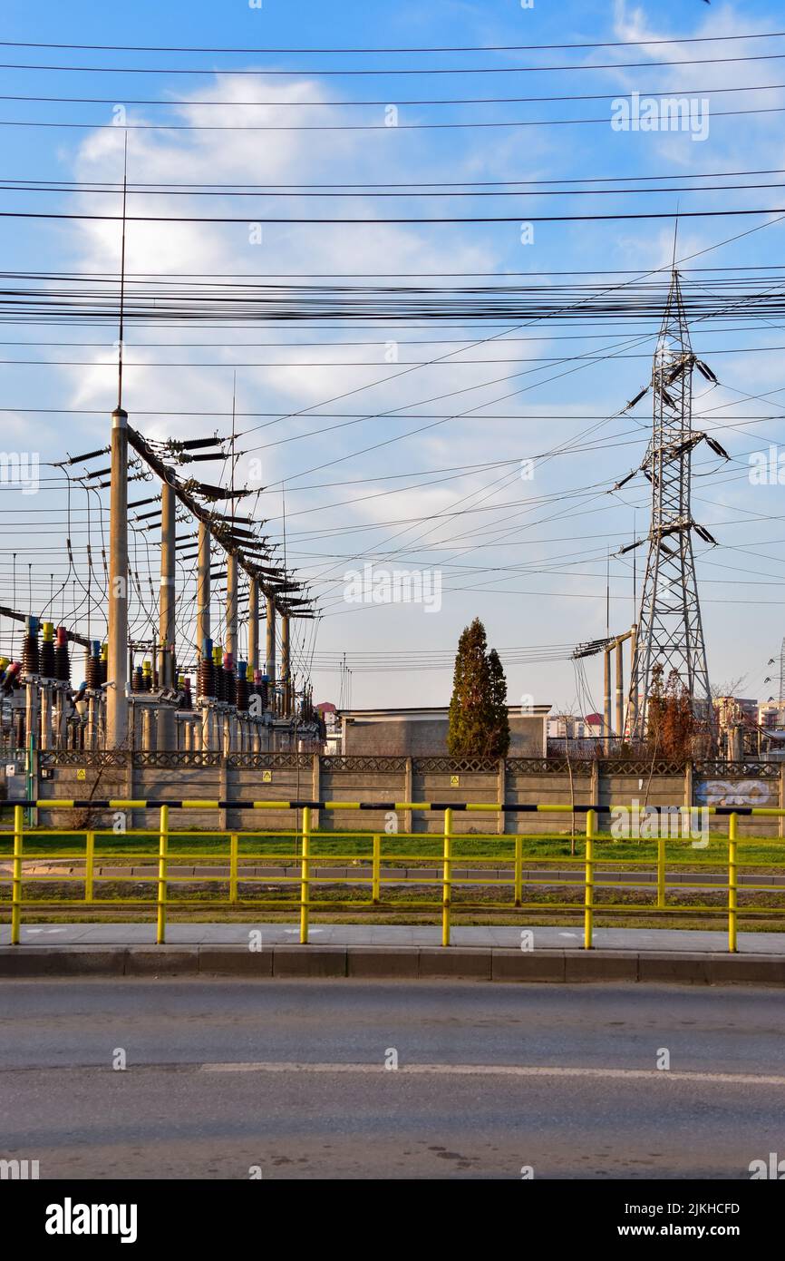 A vertical shot of the electrical poles near an electrical power plant