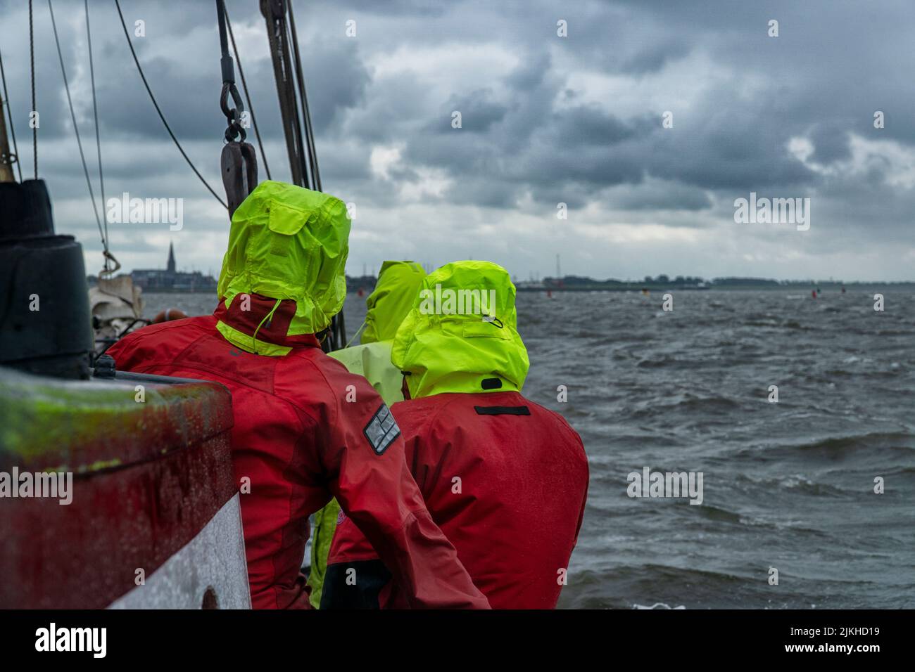 a closeup shot of men with surf drysuit on ship in the ocean Stock