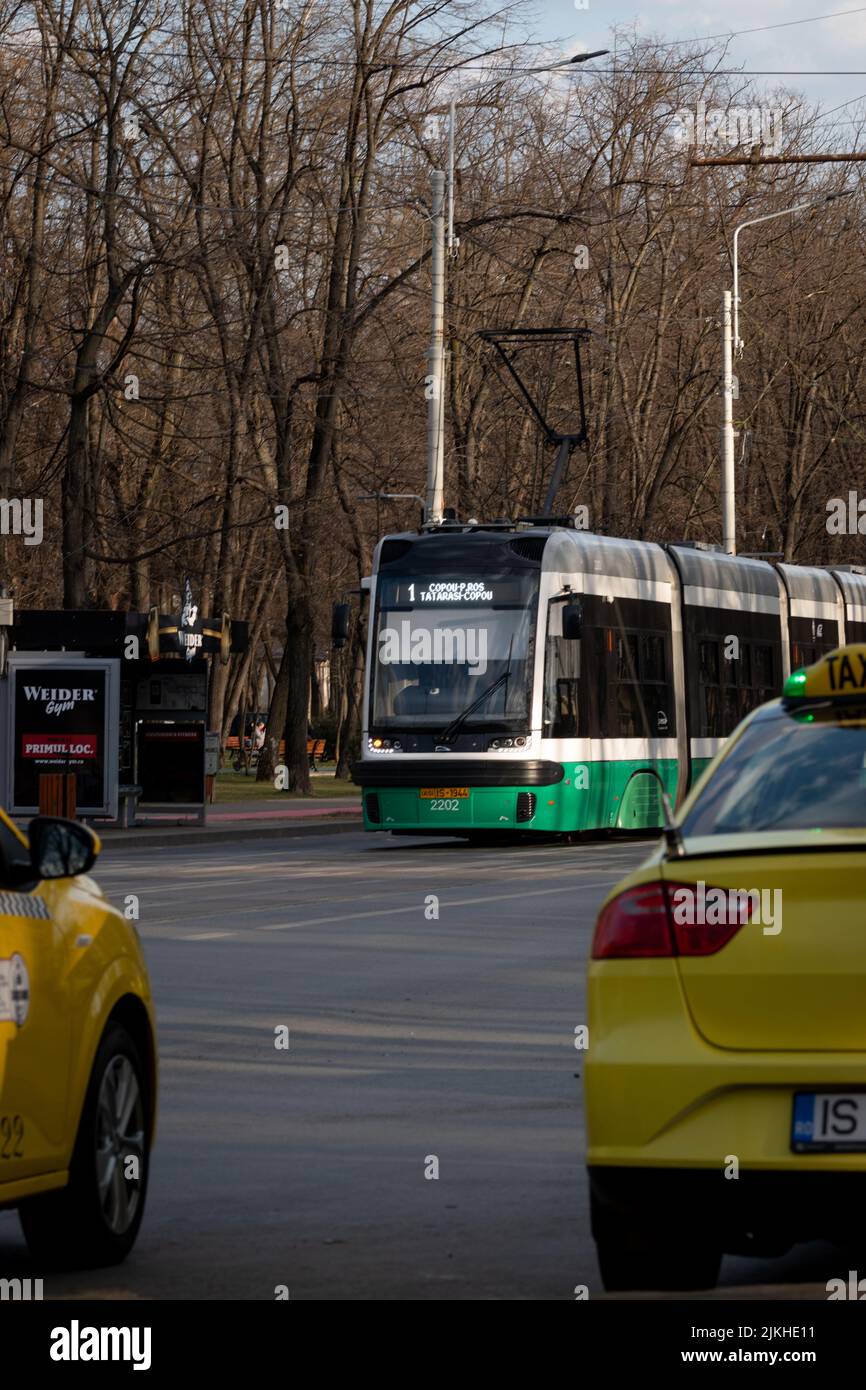 A vertical shot of public transportation - tram and taxis in the street of Iasi, Romania Stock Photo