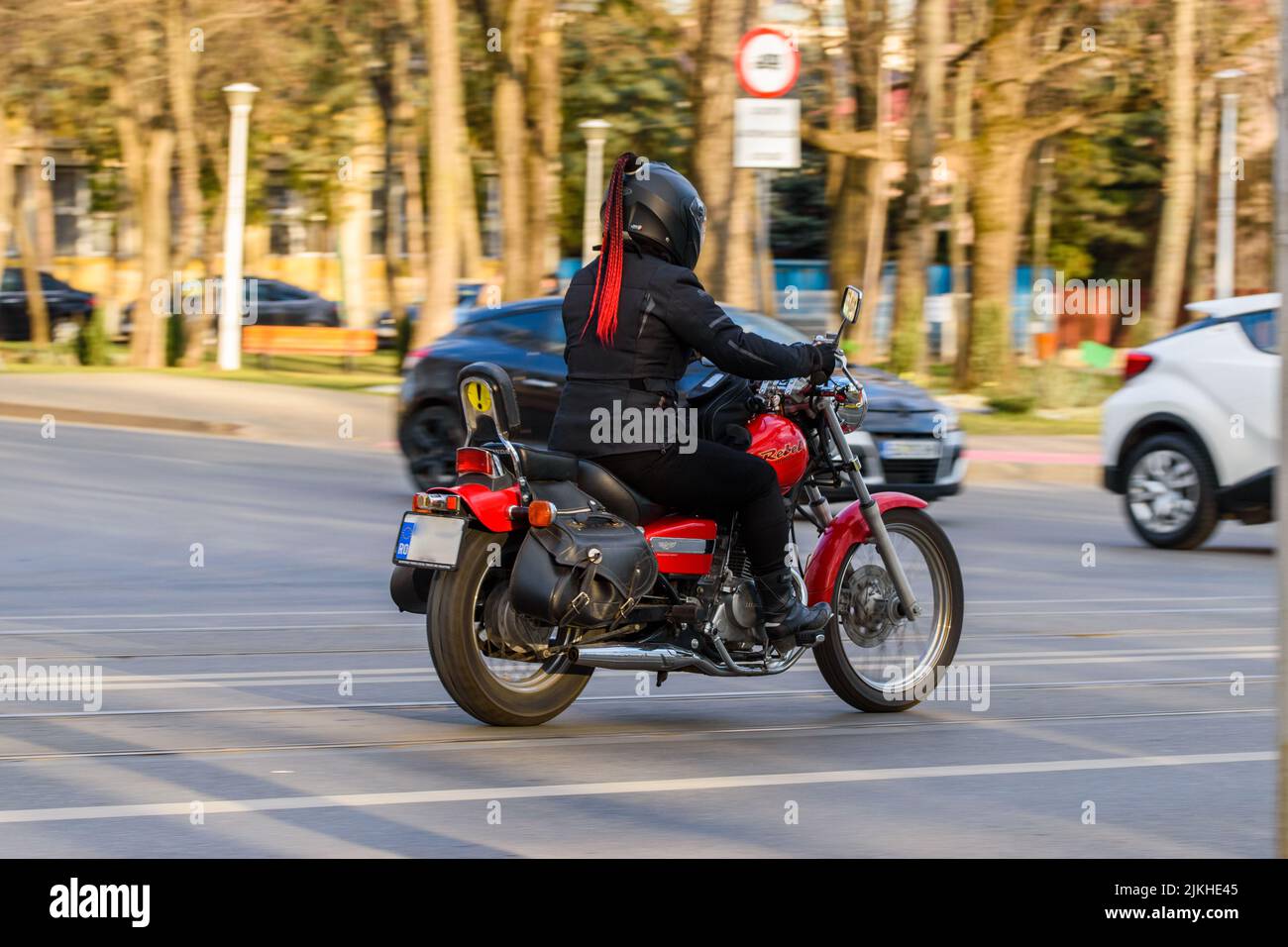 A shallow focus shot of biker lady with red hair in the street in Iasi, Romania Stock Photo