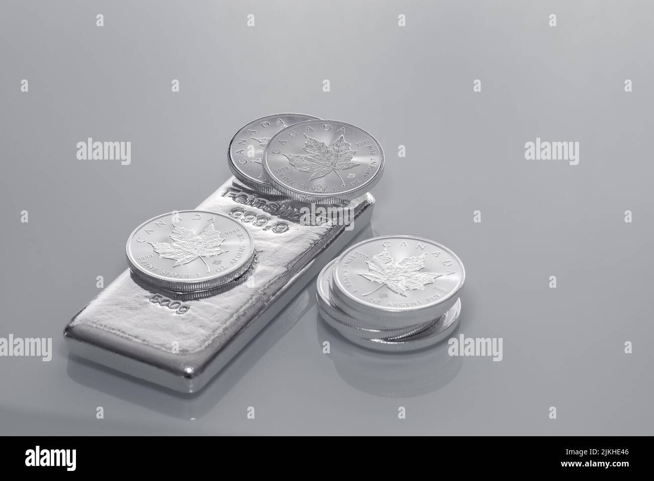 A stack of 1oz Silver Canadian Maple Leaf on gray background Stock Photo