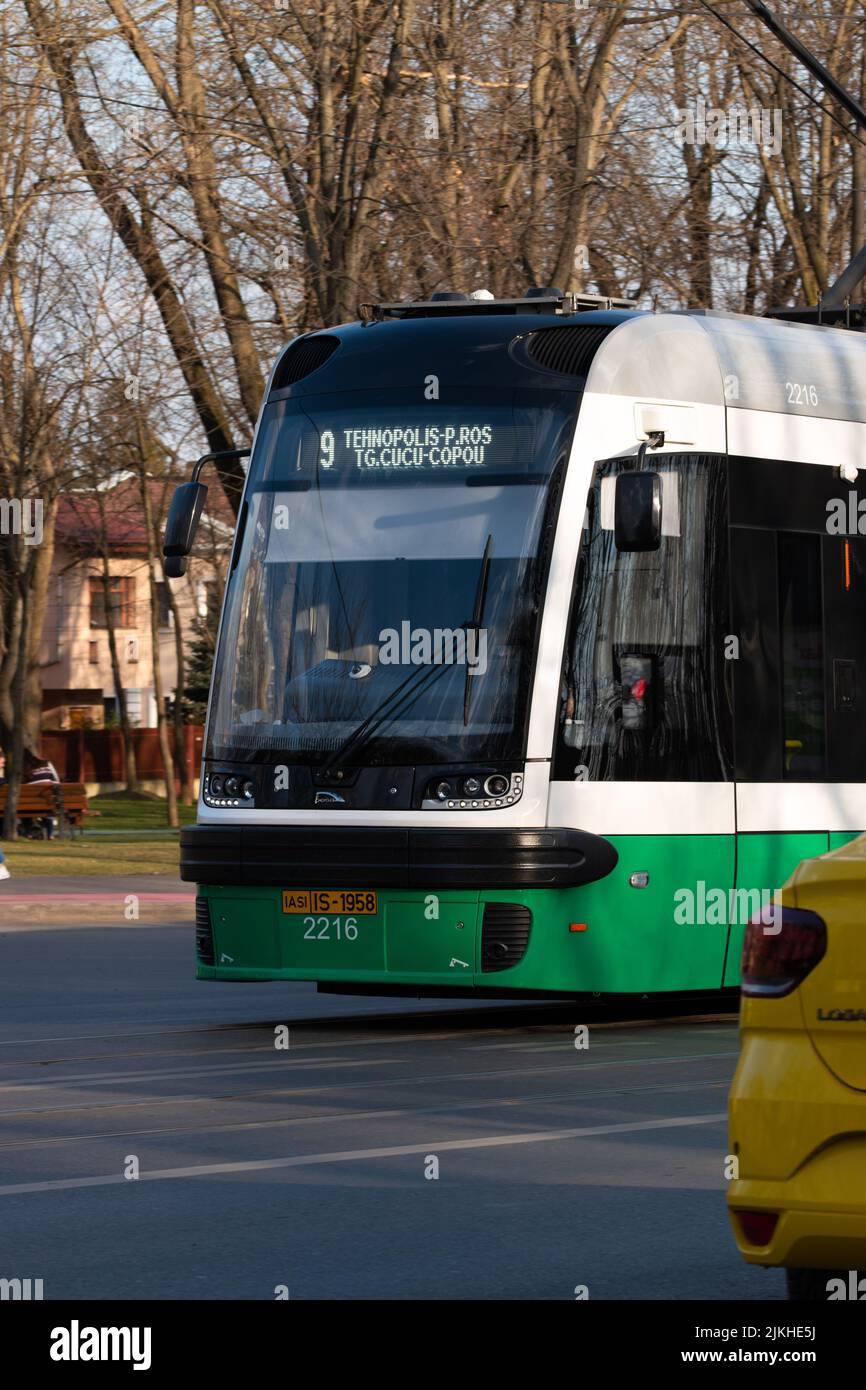 A vertical shot of green and white tram in the street of Iasi, Romania Stock Photo
