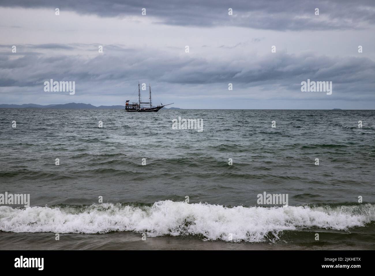 The calm waters of the sea and a lonely boat sailing across Stock Photo ...