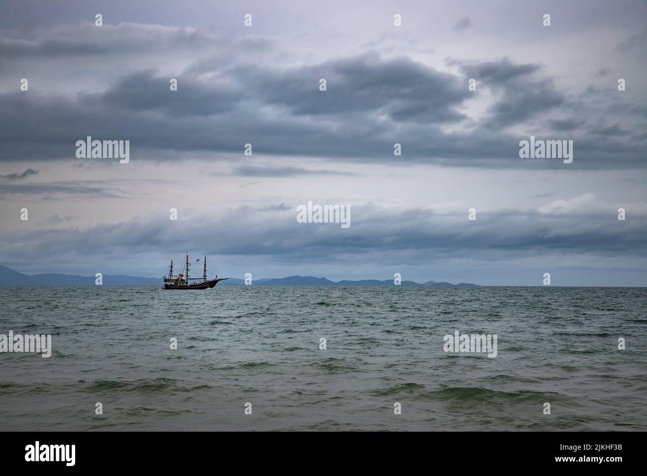 The calm waters of the sea and a lonely boat sailing across Stock Photo ...
