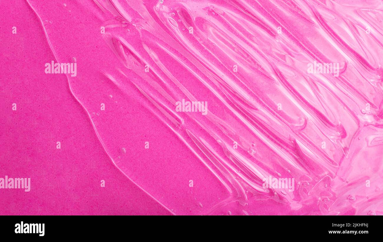 Top view of liquid cosmetics gel structure on pink background.Good as