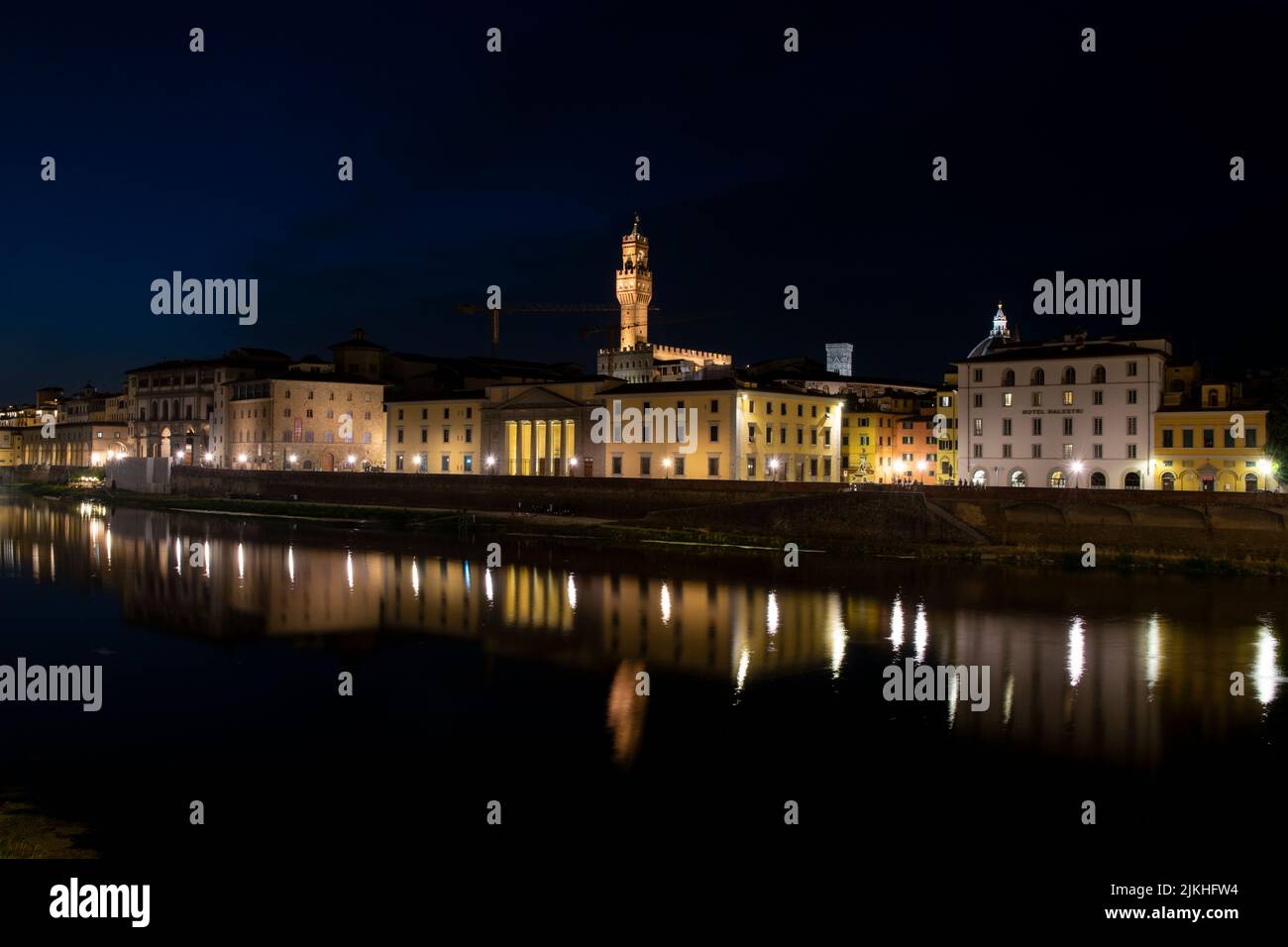 Florence skyline with city lights reflected over the Arno river, Italy Stock Photo