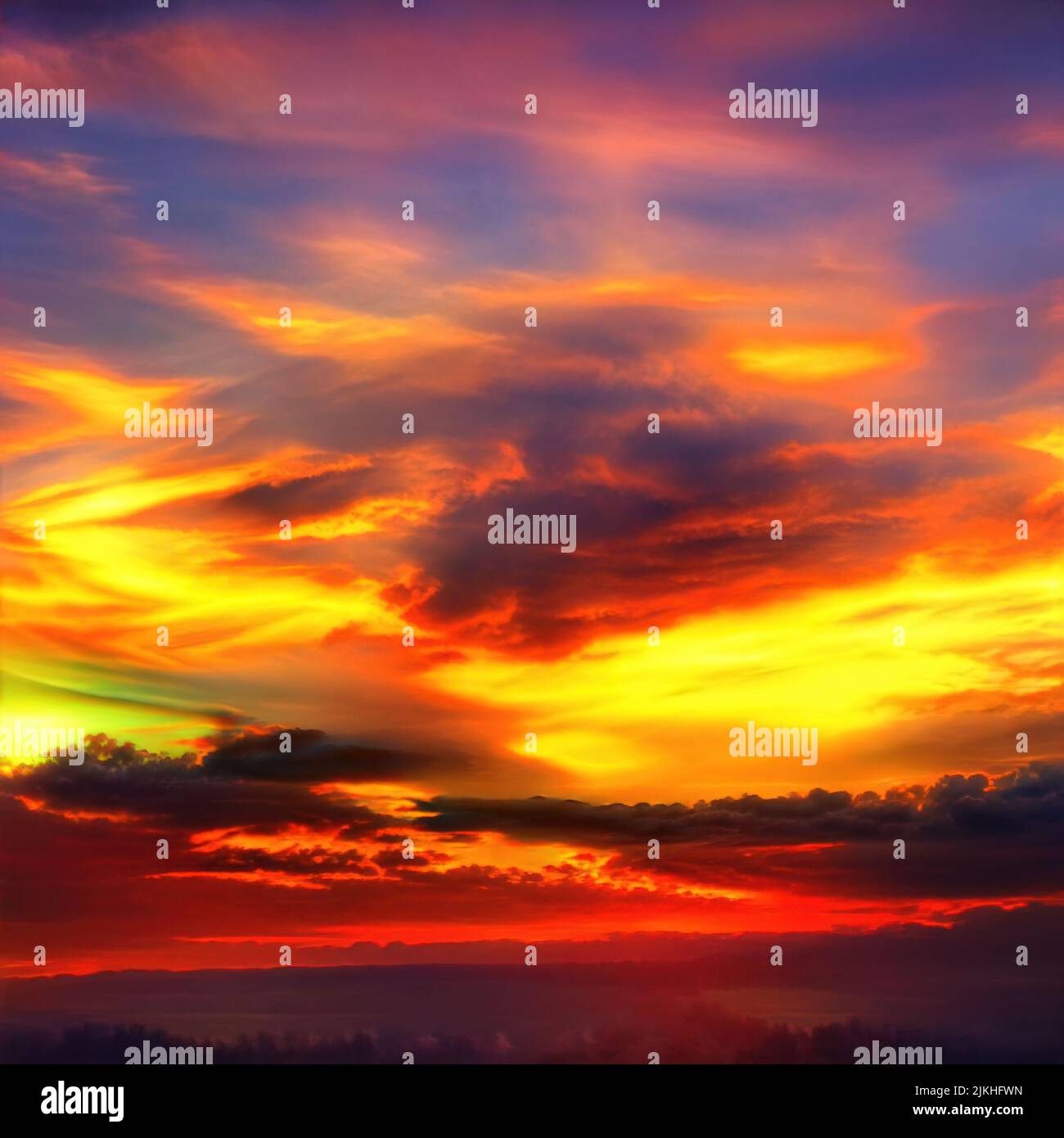 A dramatic sunset in vibrant colors over the silhouettes of trees Stock ...