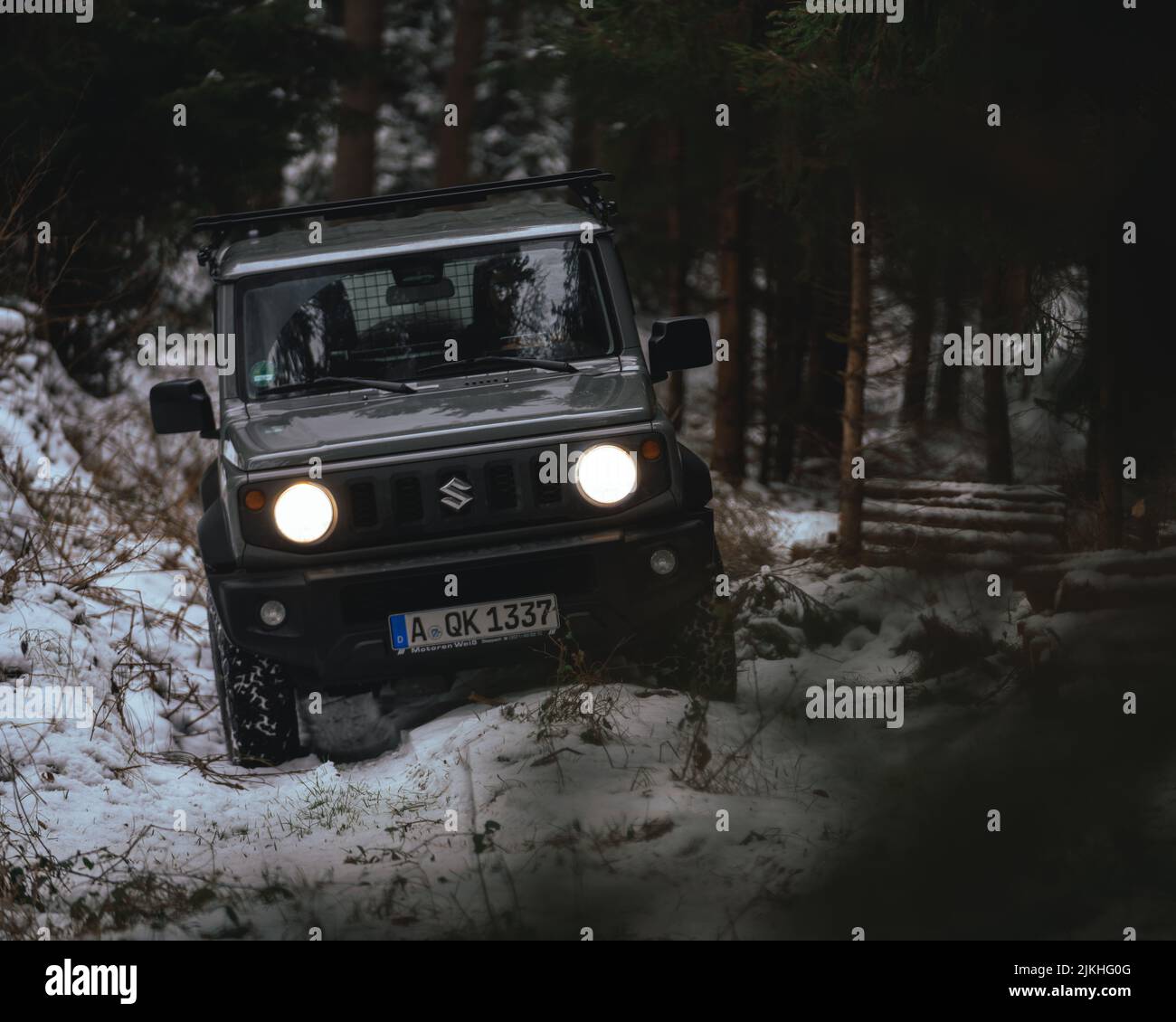 Jkhg A black Suzuki Jimny driving through the woods in winter Stock Photo ...