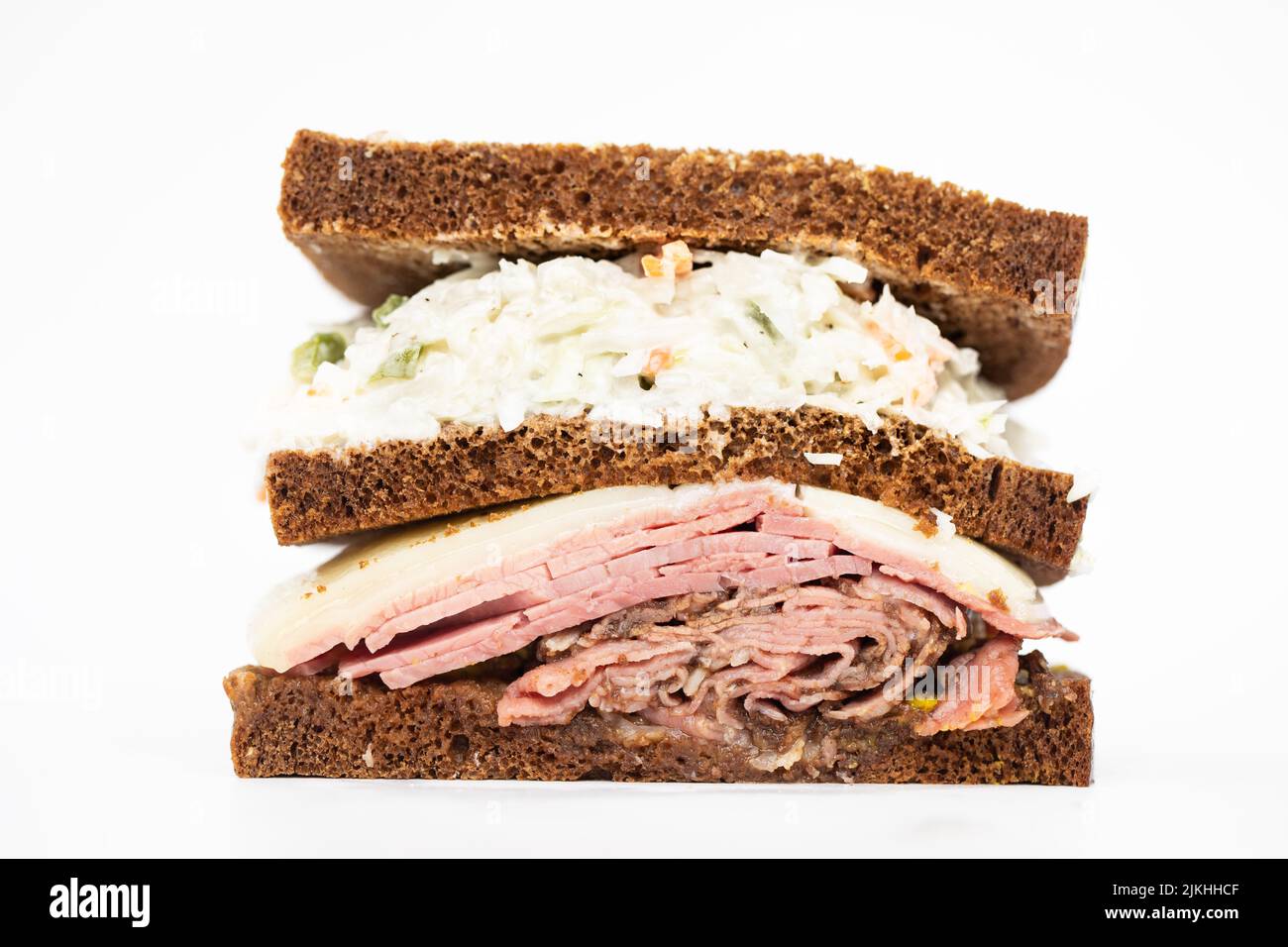 A pastrami sandwich sliced in half portraying all of its ingredients on