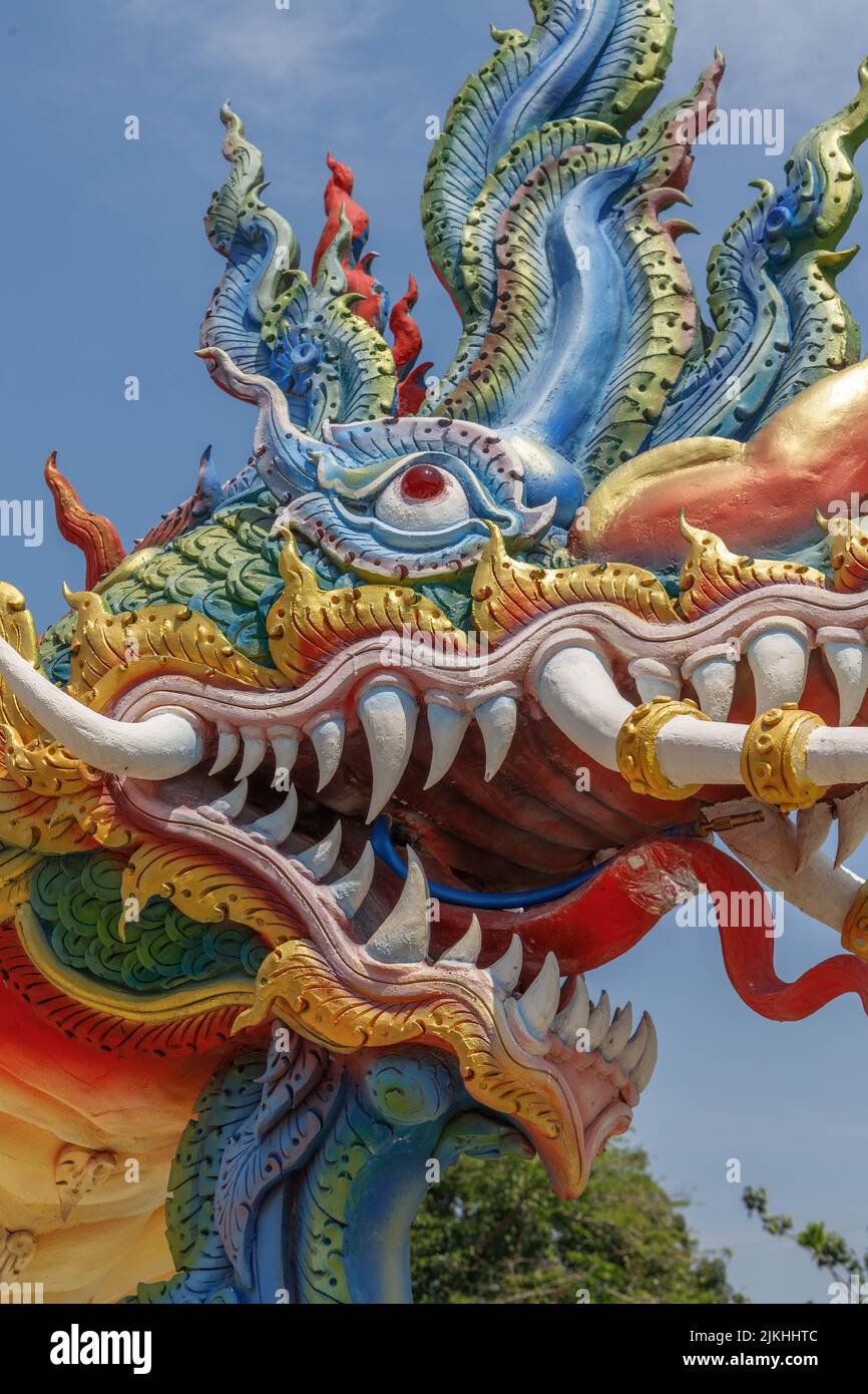 A vertical shot of a dragon head at a small village temple in Thailand Stock Photo