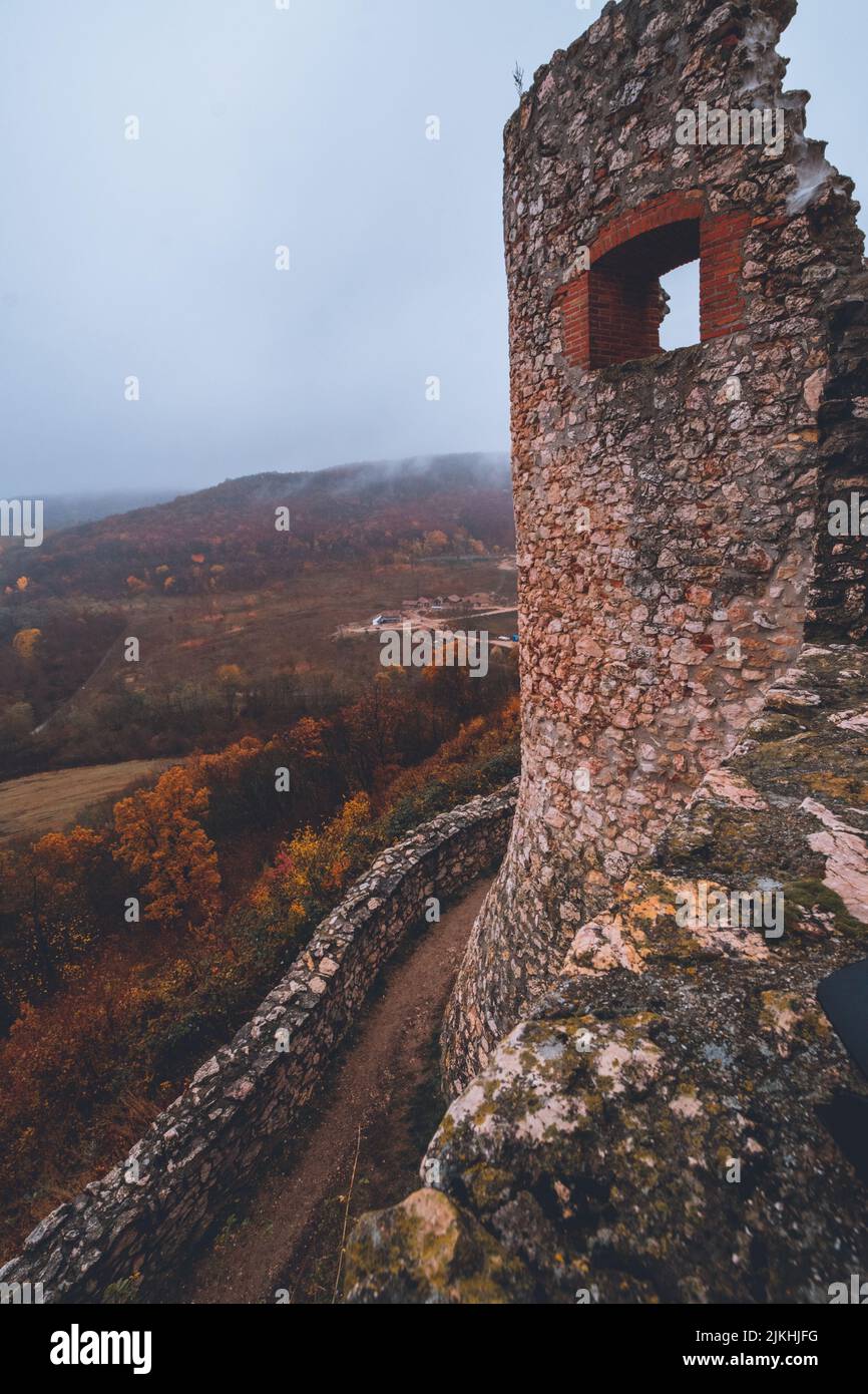 A vertical shot of the Csesznek Castle Ruins in Hungary on a foggy day Stock Photo