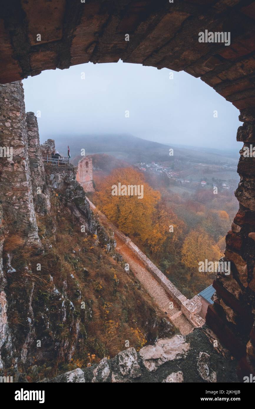 A vertical shot of the Csesznek Castle Ruins in Hungary on a foggy day Stock Photo