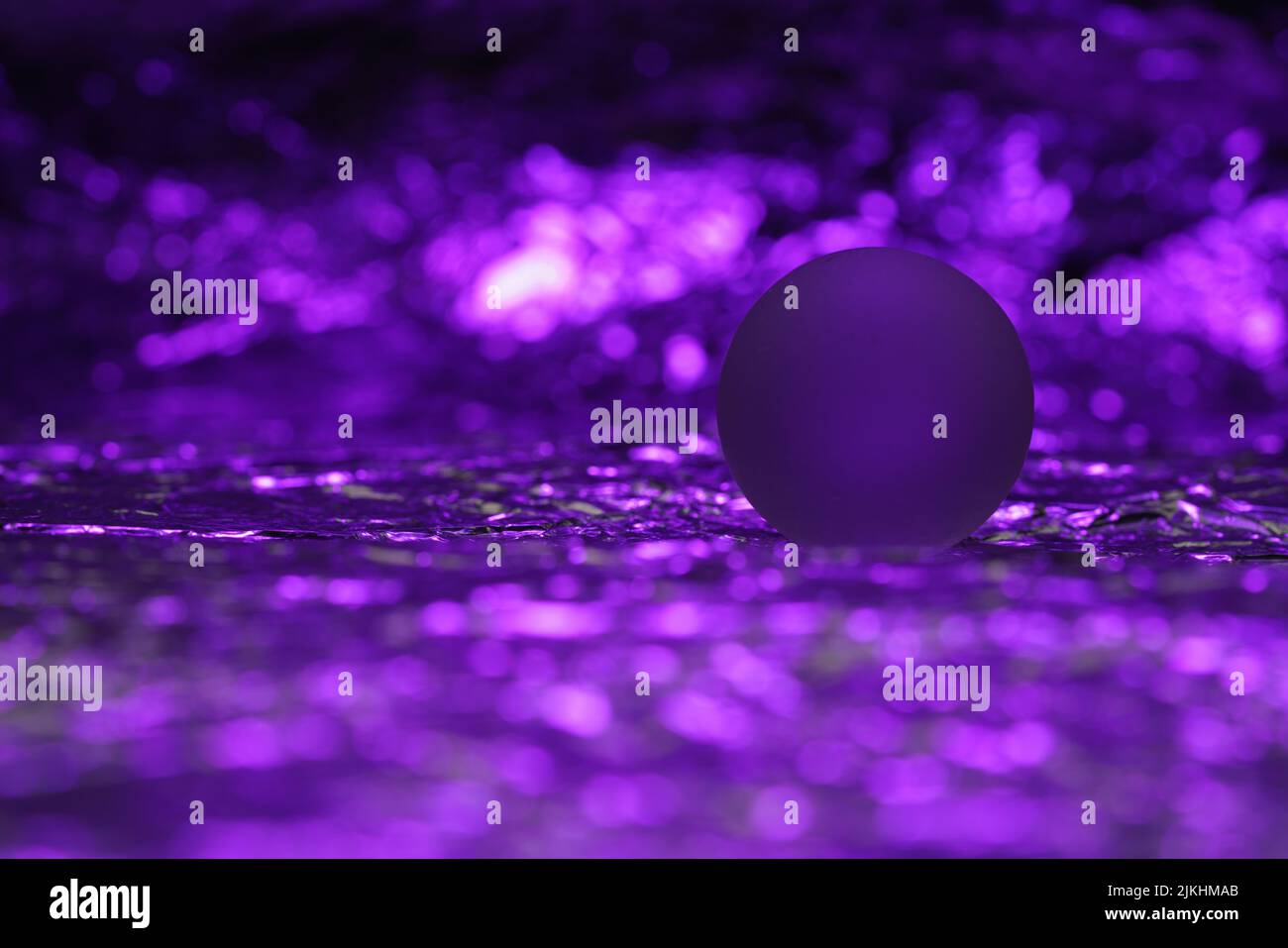 A small ball for Christmas decorations on a shiny, purple background Stock Photo