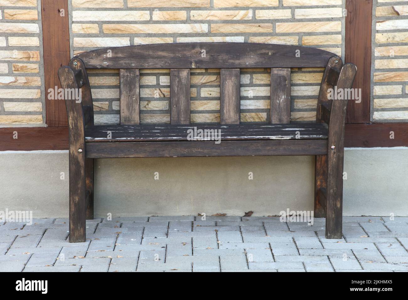 An old, wooden bench on a brick wall background Stock Photo - Alamy