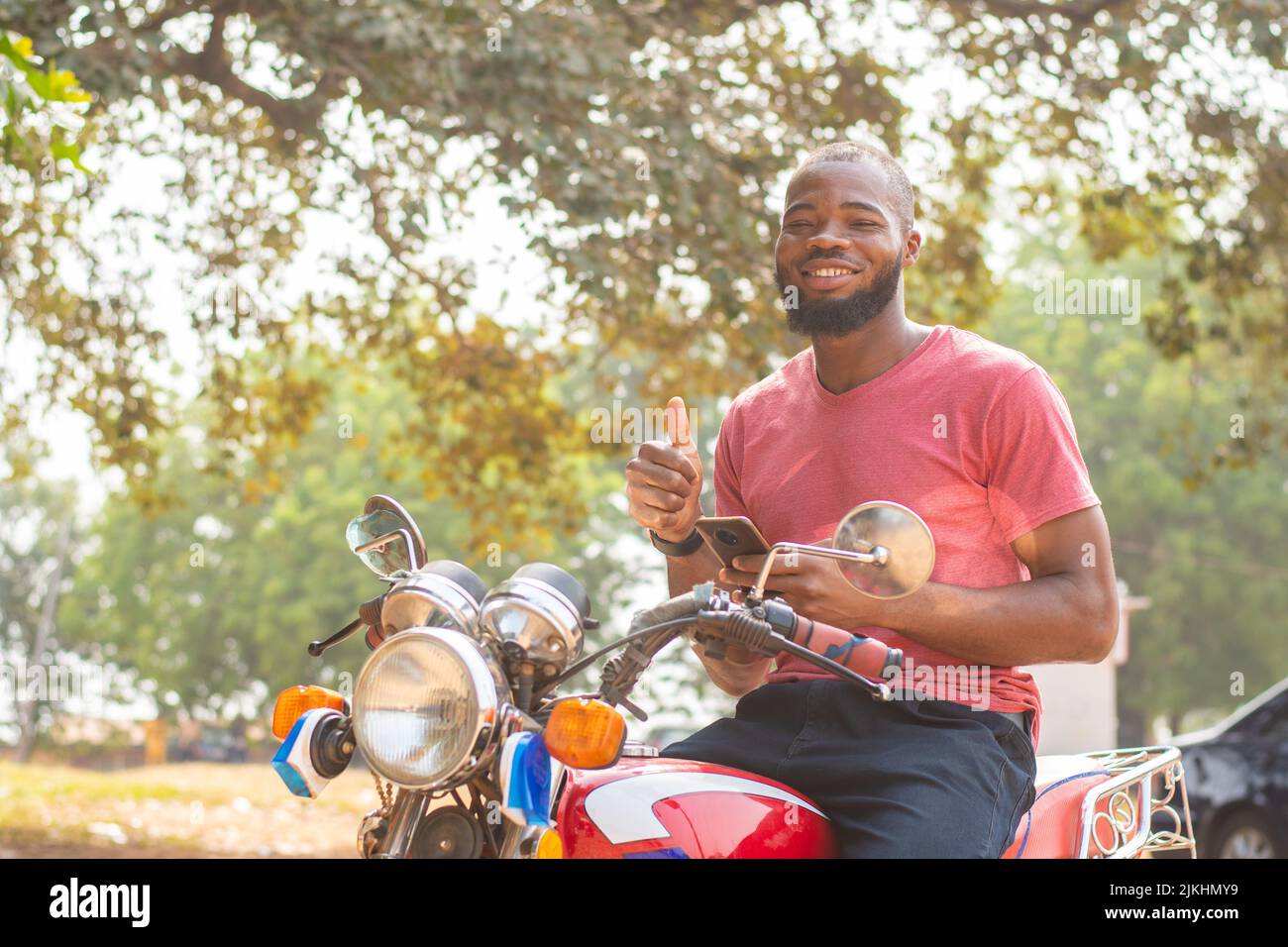 okada rider using his phone, thumbs up gesture Stock Photo