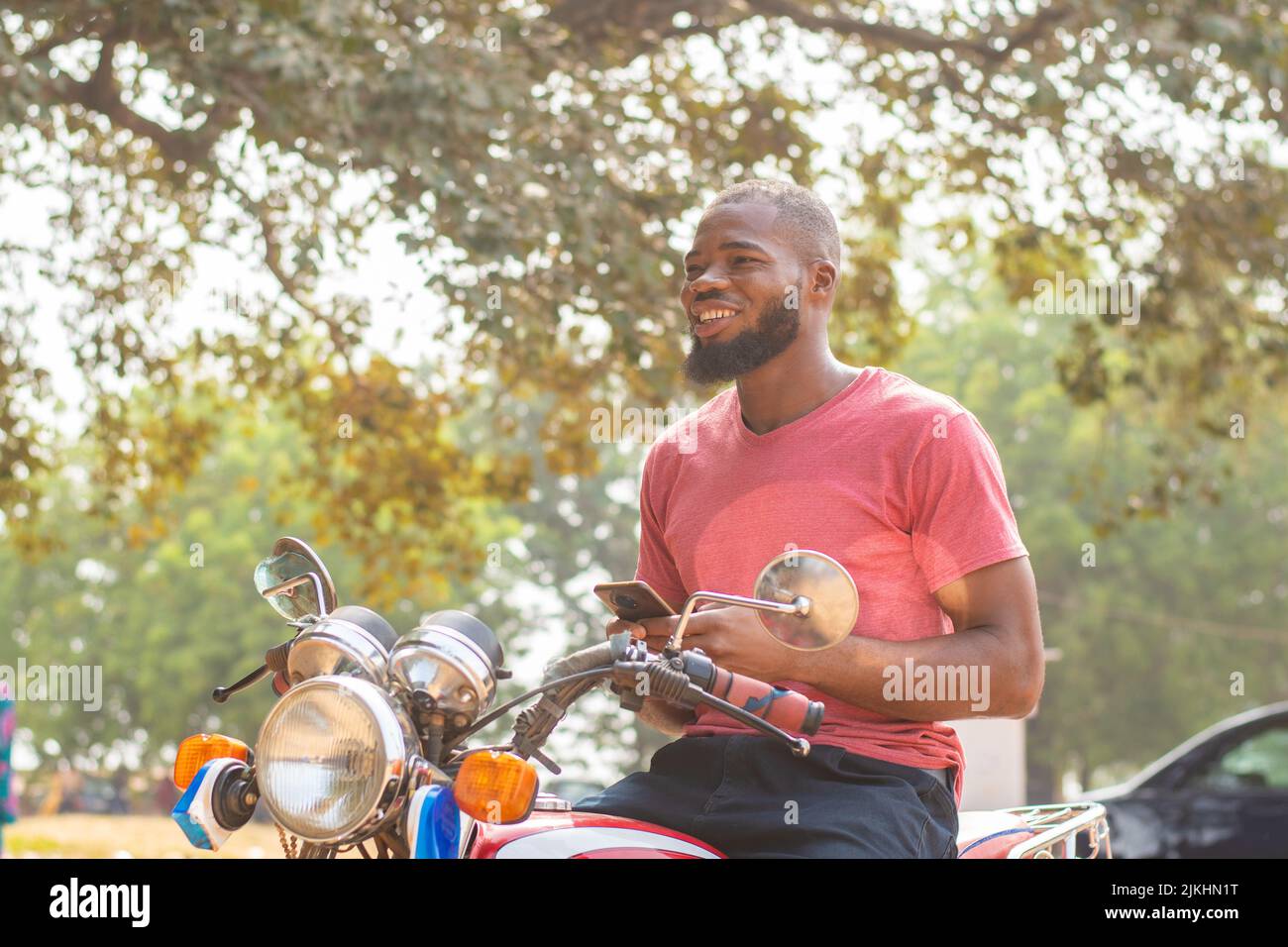 okada rider using his phone smiling Stock Photo
