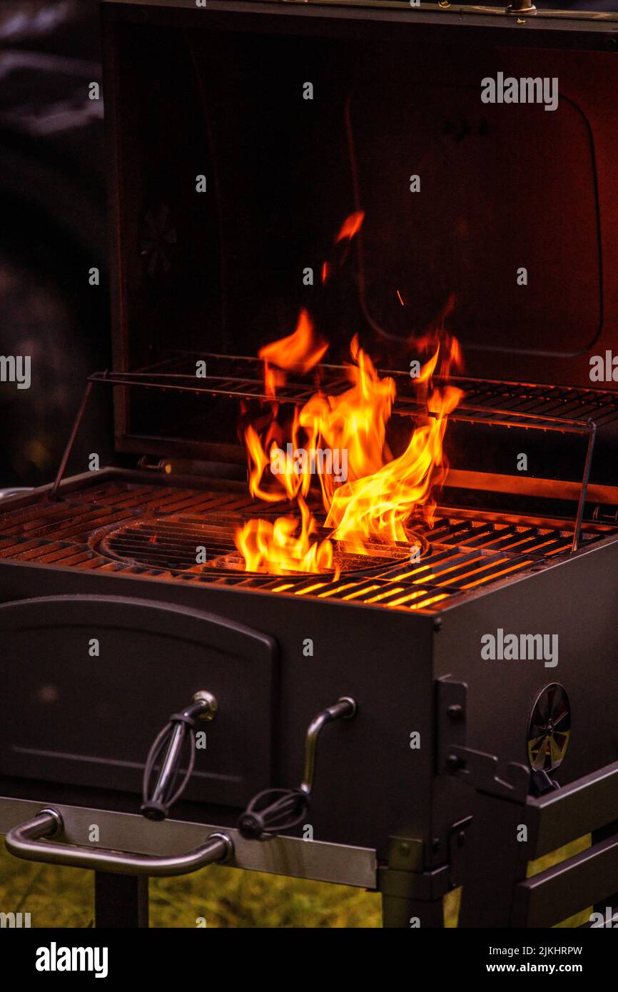 A vertical shot of burning orange flames on a grill Stock Photo Alamy