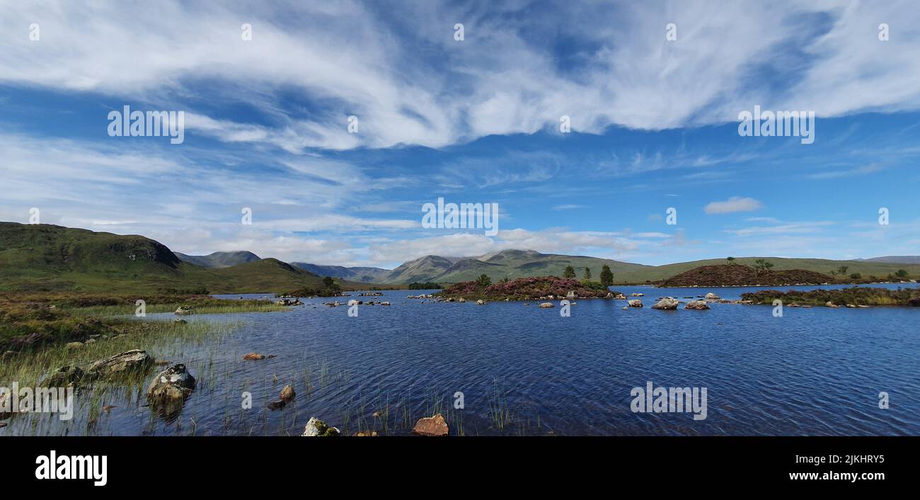 A breathtaking view of a lake with cloudy clear blue sky Stock Photo ...